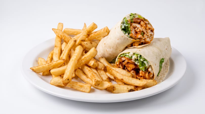 Two chicken wraps with lettuce and sauce, served with a side of golden french fries on a white plate.